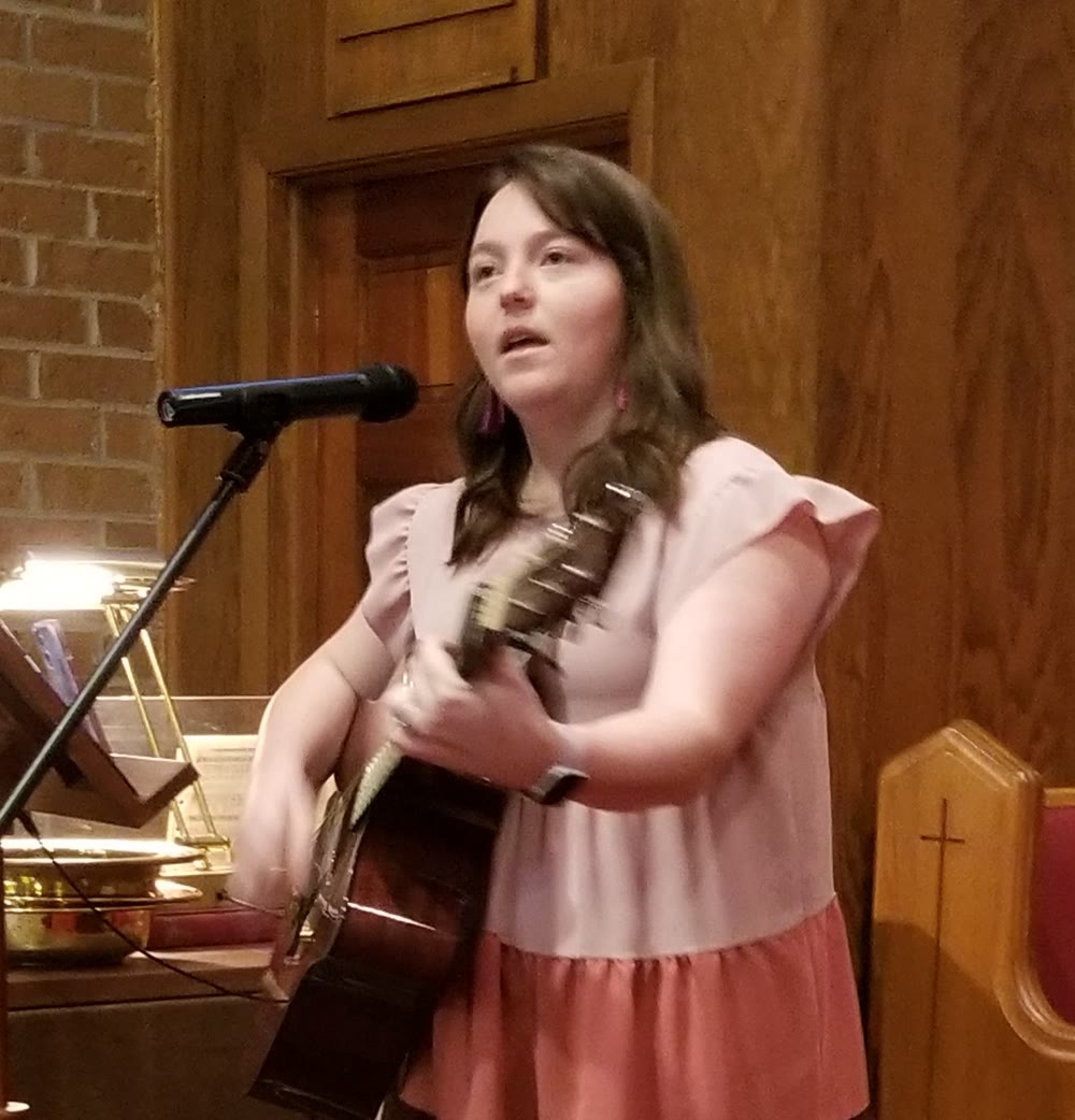 Katie Moore, Contemporary Worship Leader at Herbert UMC, singing and playing guitar